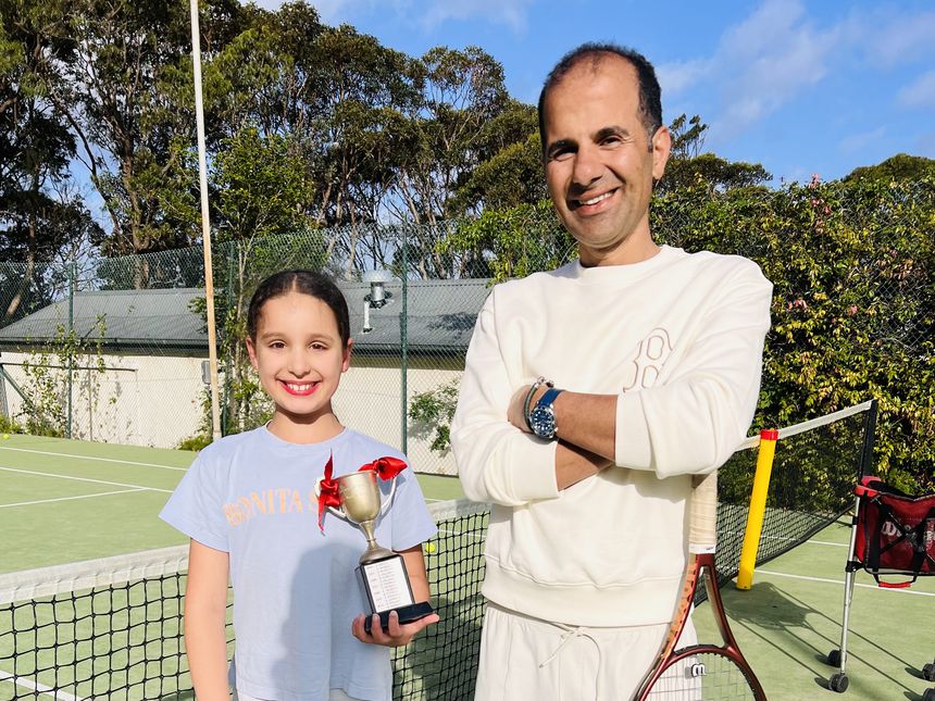 A junior player with a tournament trophy